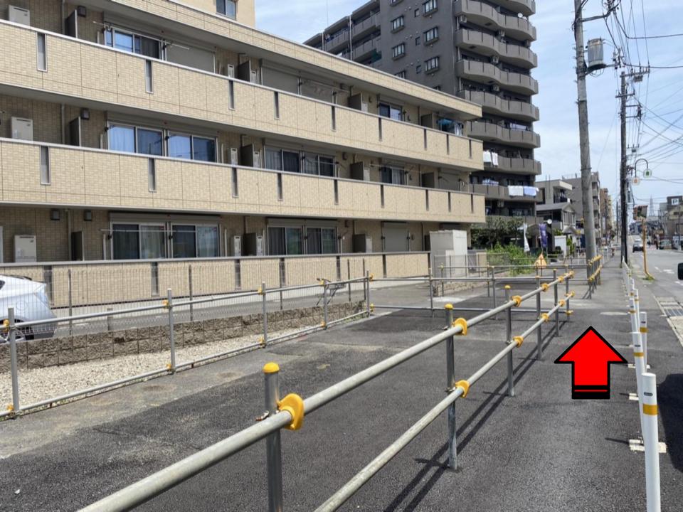 ベージュのアパートがあります。真っ直ぐ進みます。